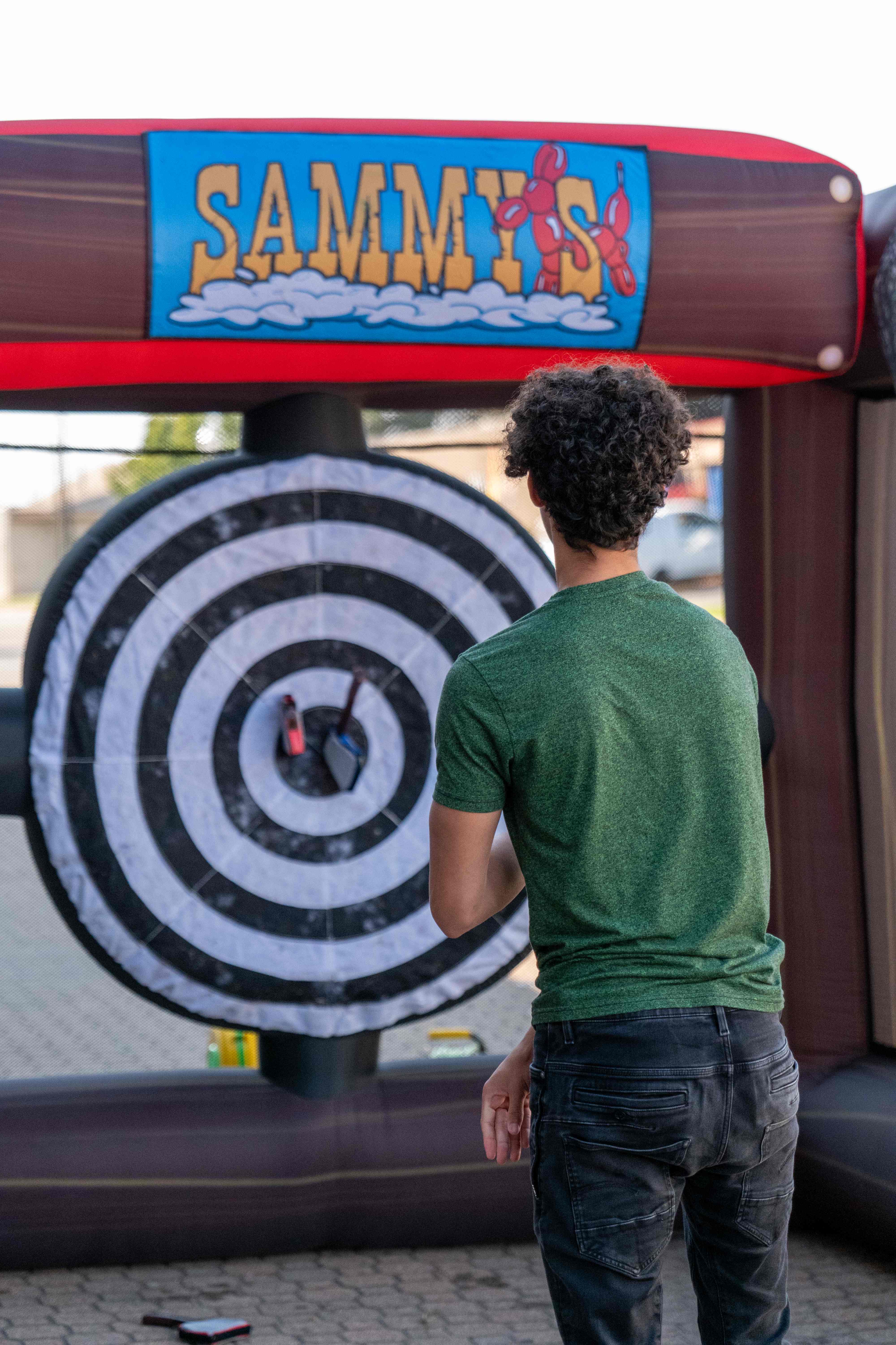 Person playing cornhole game at Recovery Fest